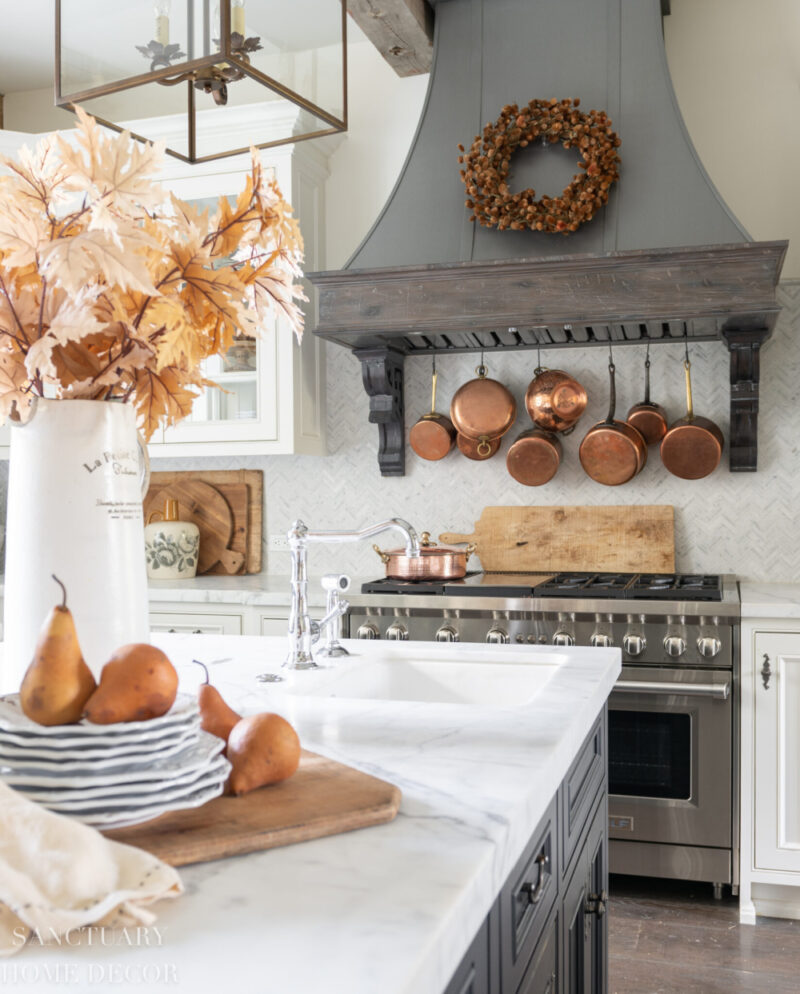 fall decor in kitchen with copper cookware and fall foliage