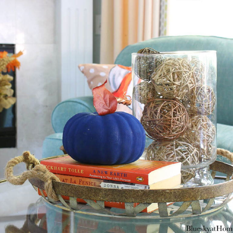 cozy fall living room decorated with blue painted pumpkin on a metal tray