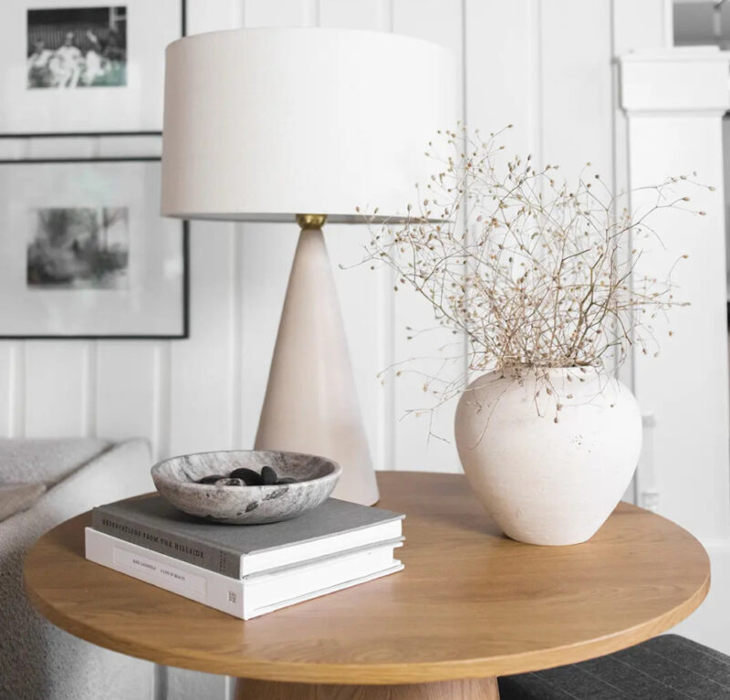 fall stems on in a natural vase with a white lamp on wood table