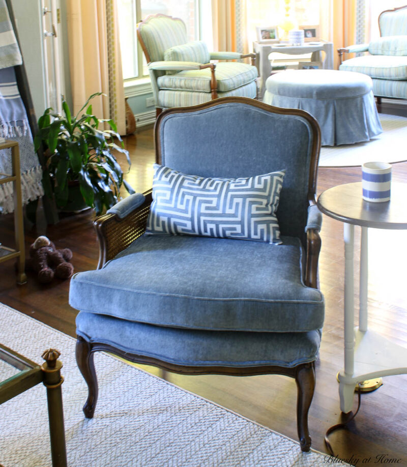 blue bergere chair with patterned pillow