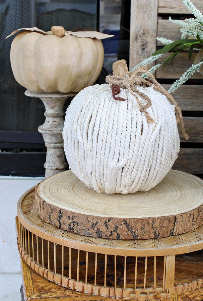 white yarn pumpkin on wood slice