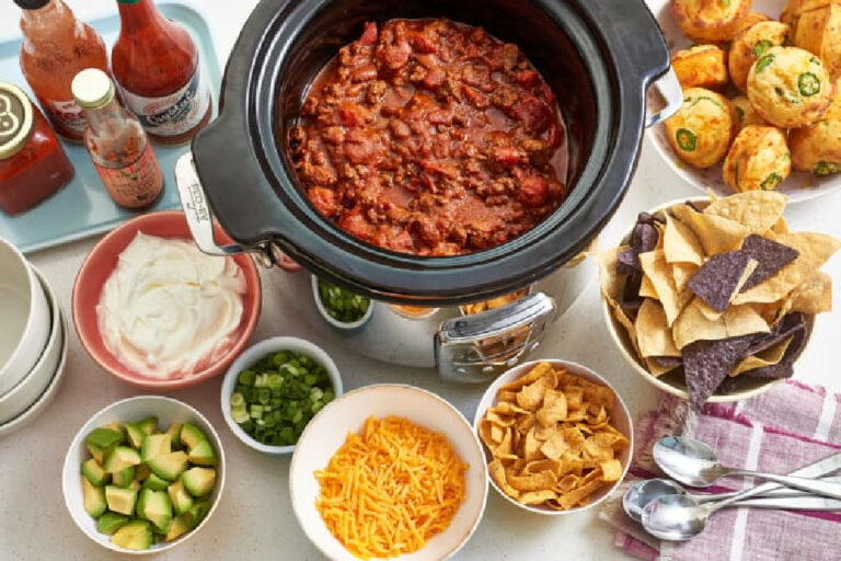 crock pot full of chili with granishes for fall party