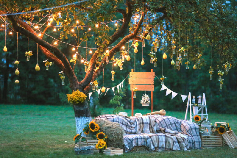 outdoor fall garden party with lights in the trees and compy sofa.