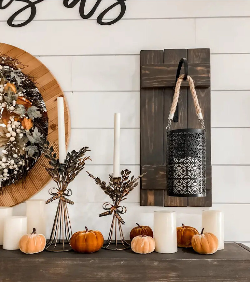 fall mantel with lantern and orange pumpkins