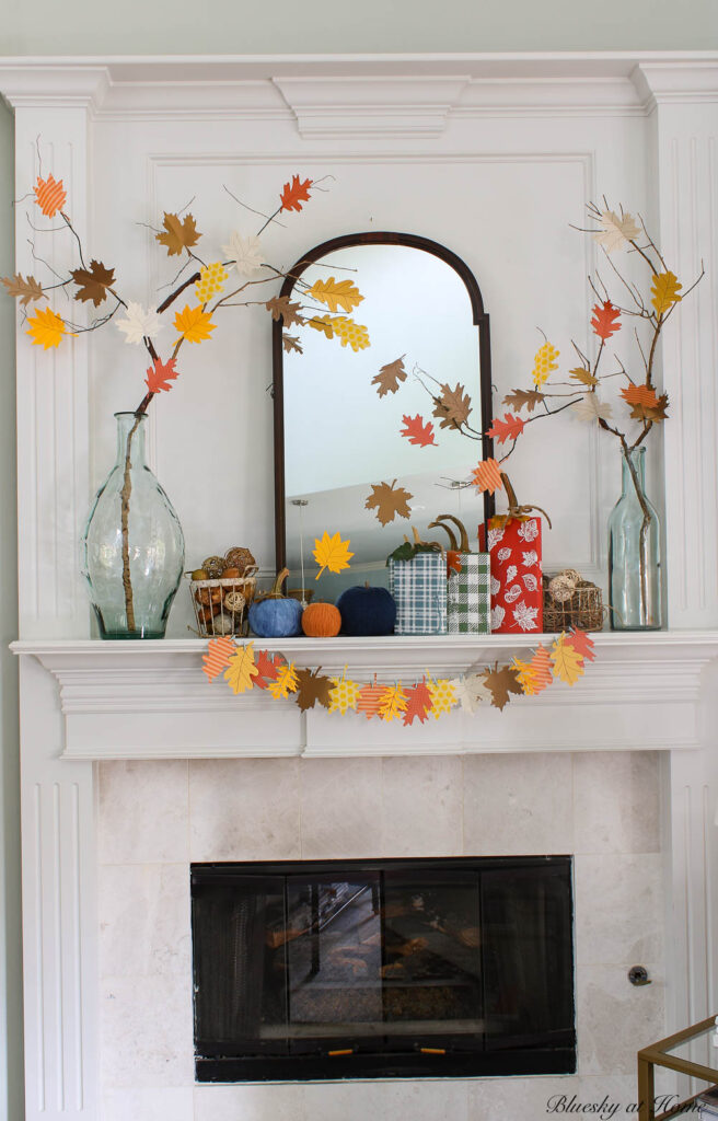fall mantel with paper leaf garland, tree, and pumpkins