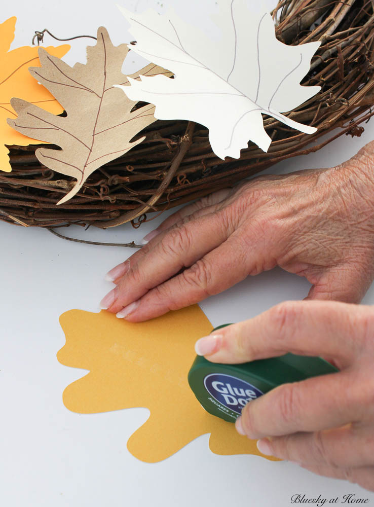 attaching glue dots to the back of the yellow paper leaf