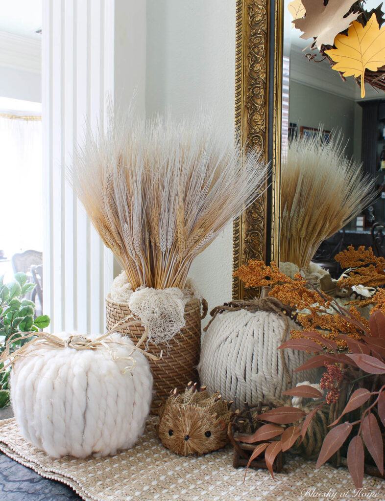 wheat arrangement with white rope and yarn pumpkins