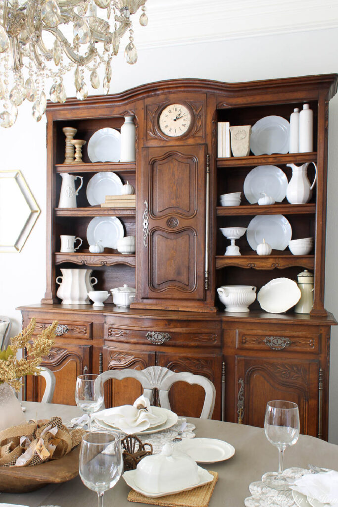 French hutch decorated with white dishes and accessories