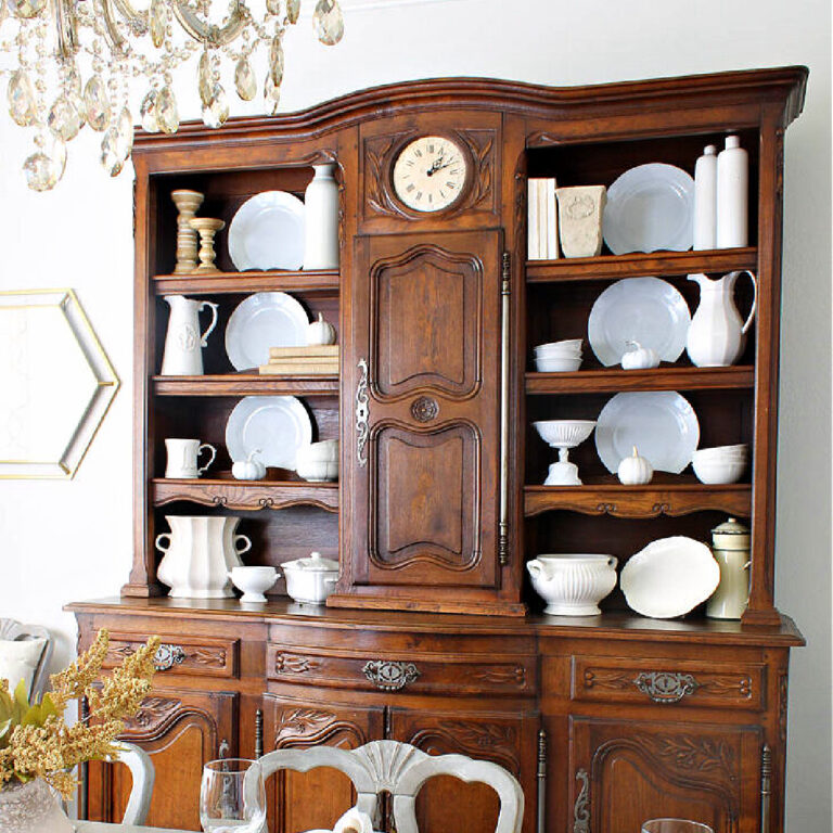 hutch styled for fall in cream and white dishes