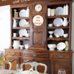 hutch styled for fall in cream and white dishes