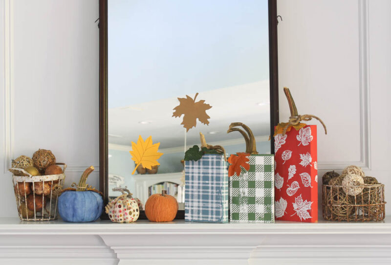 fall mantel with wood block pumpkins in red, green, and blue and pumpkins