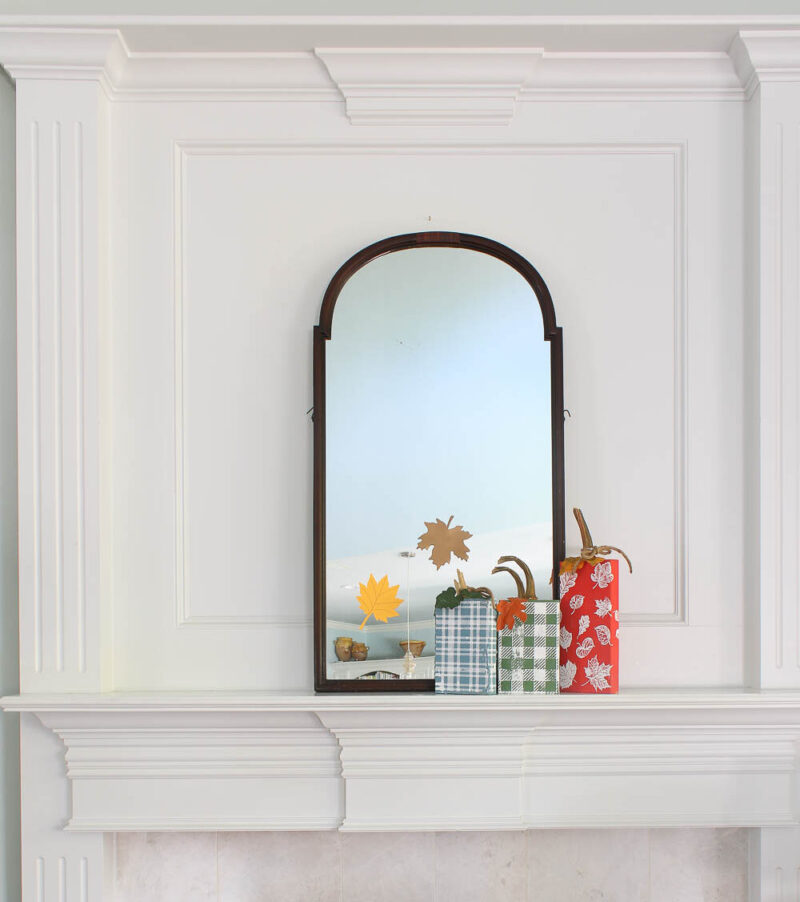 large mirror on mantel with wood block pumpkins in blue, green, and red