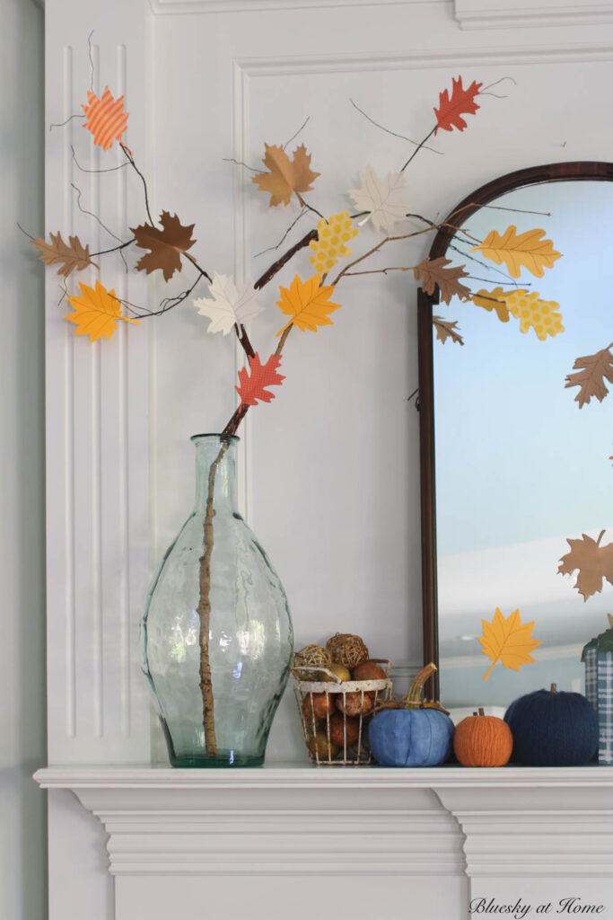 red, blue, and green wood block pumpkins on matnel with glass jar