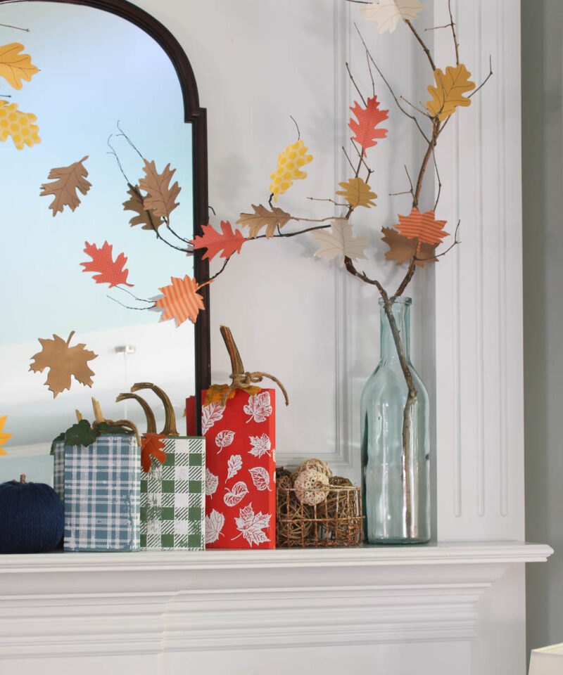 red, blue, and green wood block pumpkins on matnel with glass jar