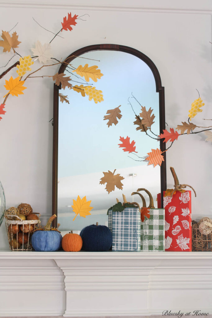 red, blue, and green wood block pumpkins on matnel with glass jar