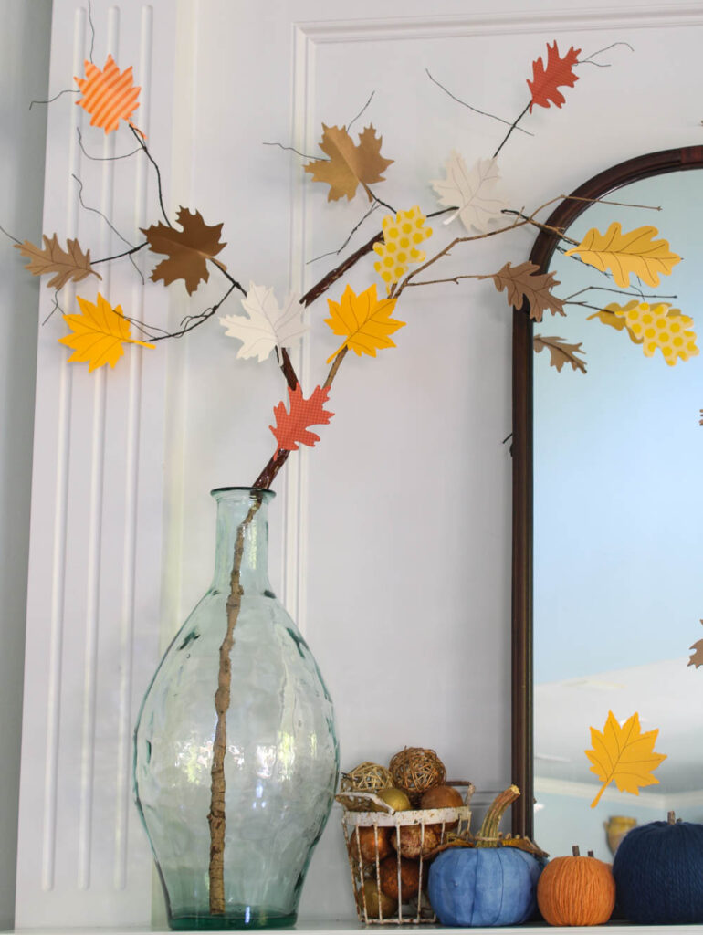 red, blue, and green wood block pumpkins on matnel with glass jar