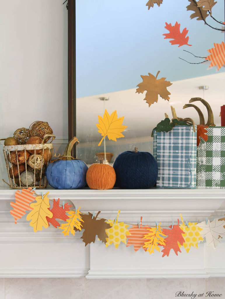 fall mantel with leaf garland and wood pumpkins