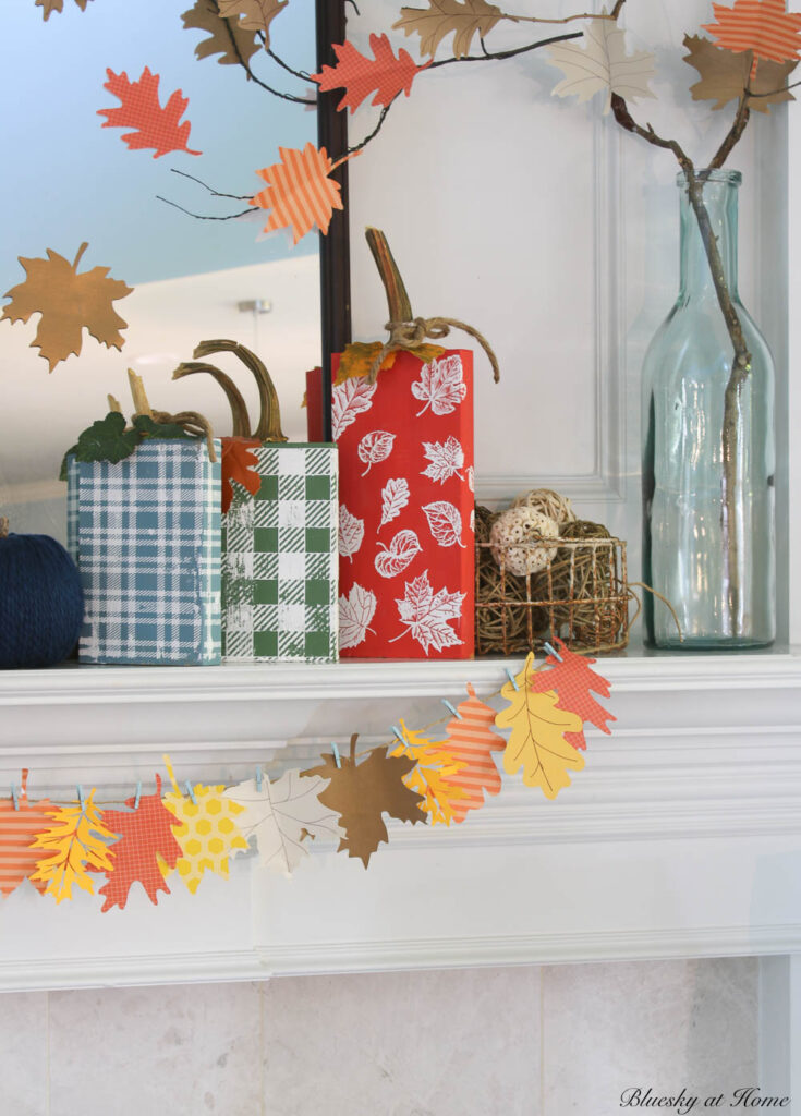 fall mantel with leaf garland and wood pumpkins