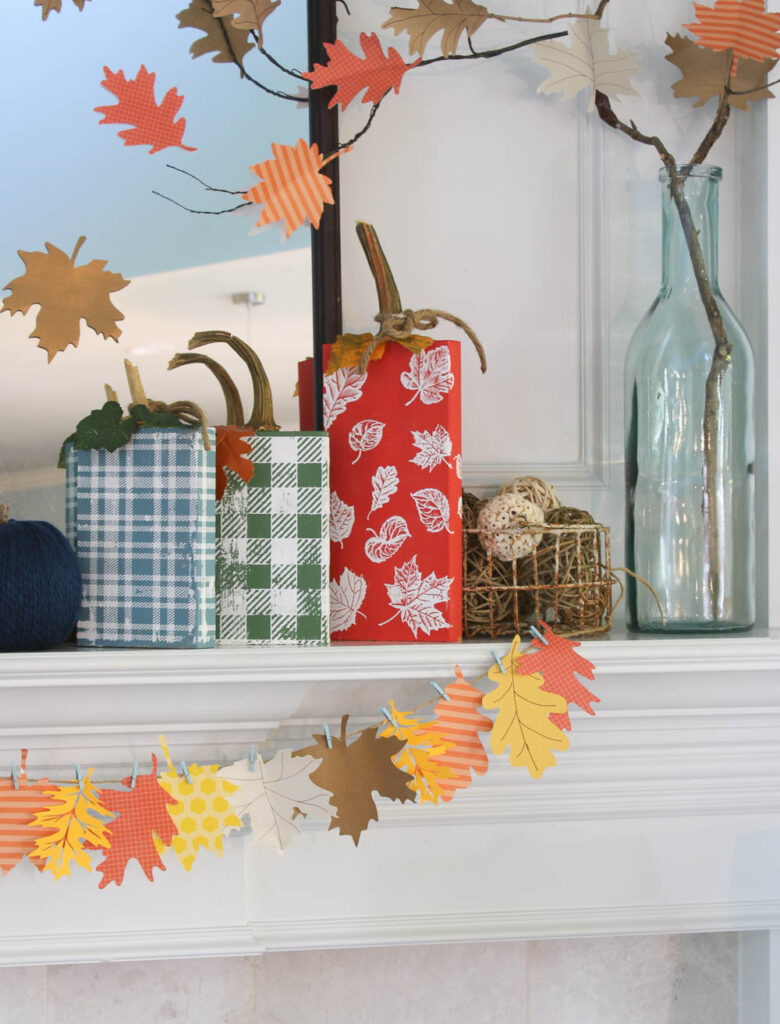 fall mantel with leaf garland and wood pumpkins