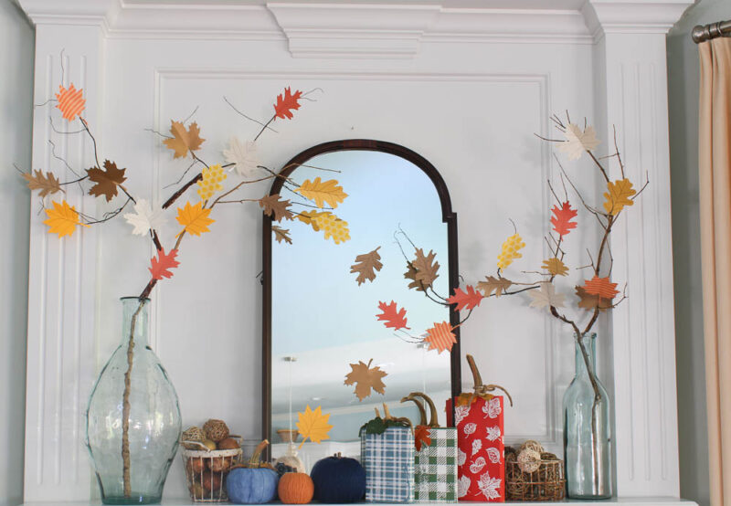 fall mantel with wood and yard pumpkins in red, orange, blue, navy and basket of fall balls