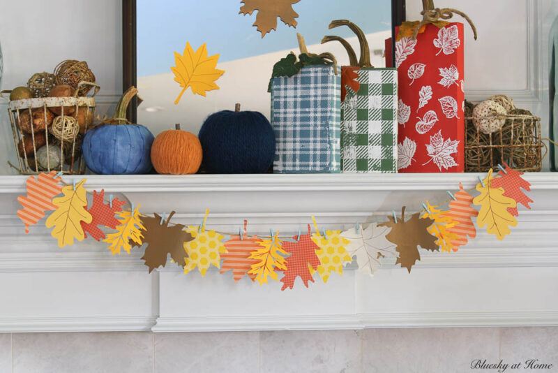fall mantel with leaf garland and wood pumpkins