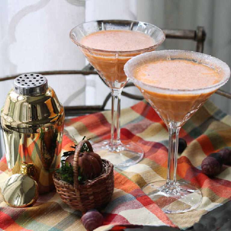 two pumpkin martinis with gold shaker on plaid napkin