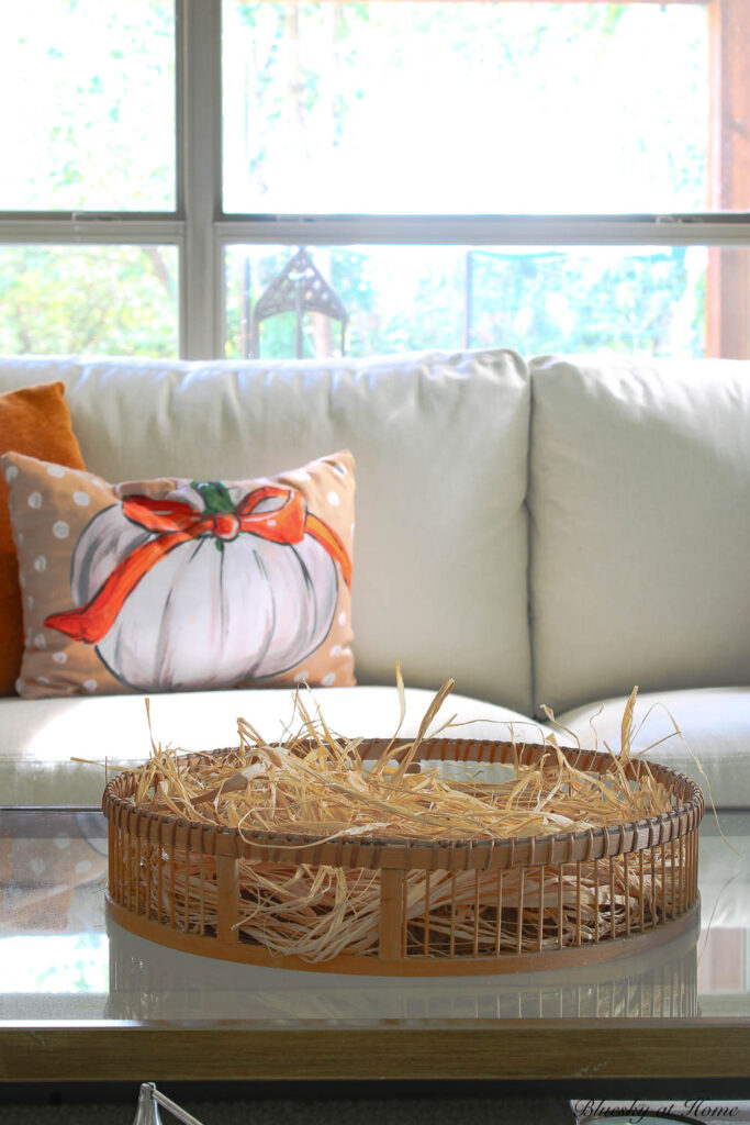 round basket with raffia in front of white sofa