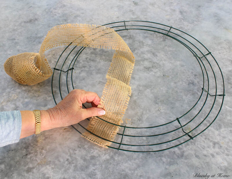 wrapping burlap ribbon around Thanksgiving wreath