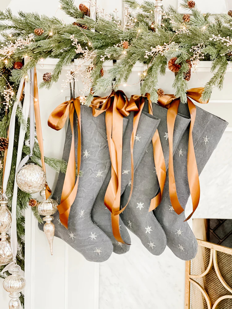 Christmas mantel with grey stockings and copper ribbons