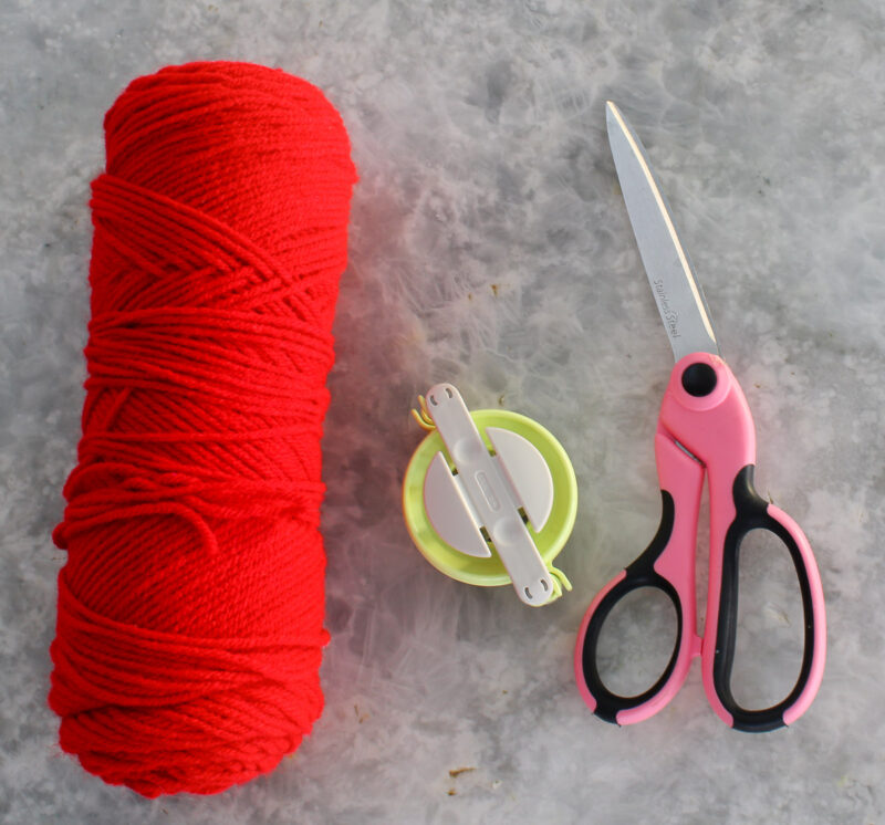 red yarn, pom-pom maker, scissors