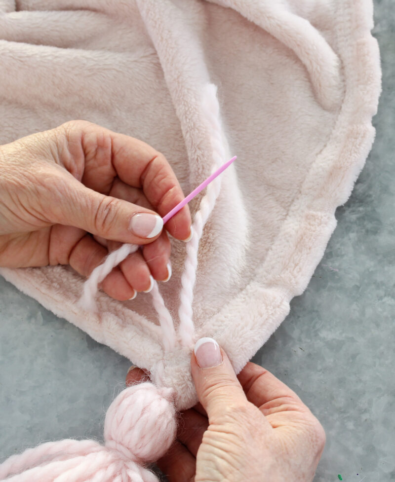 sewing tassel to pink throw