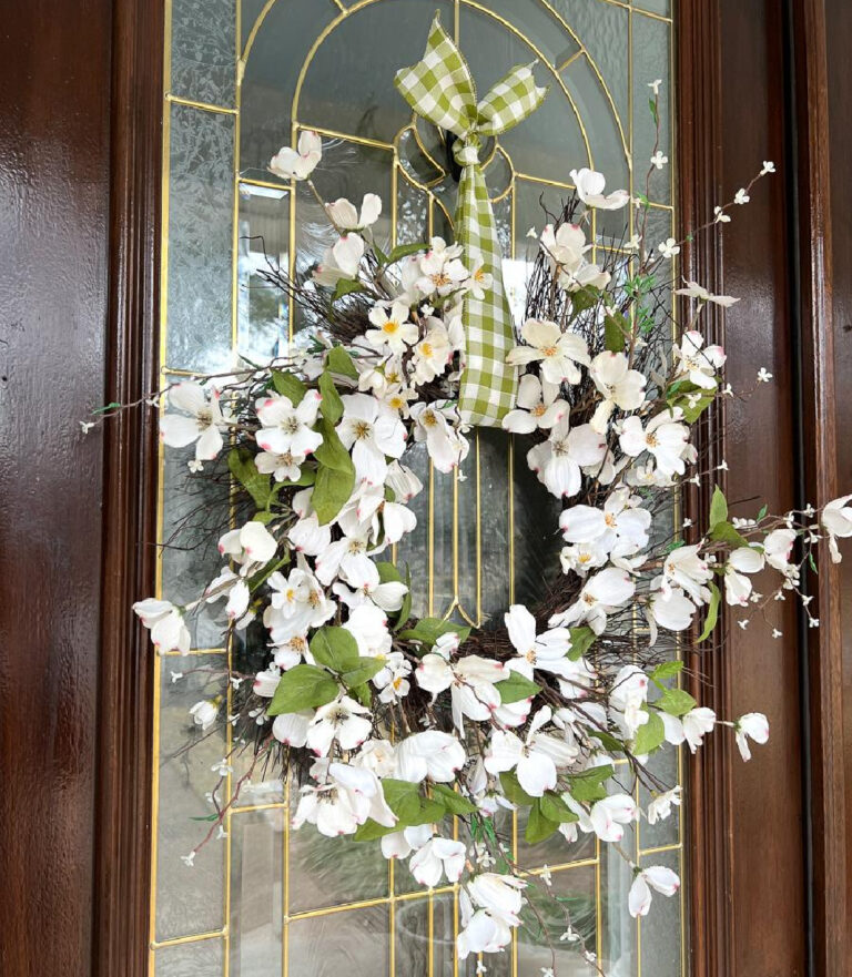 white flower wreath with green check bow on front door