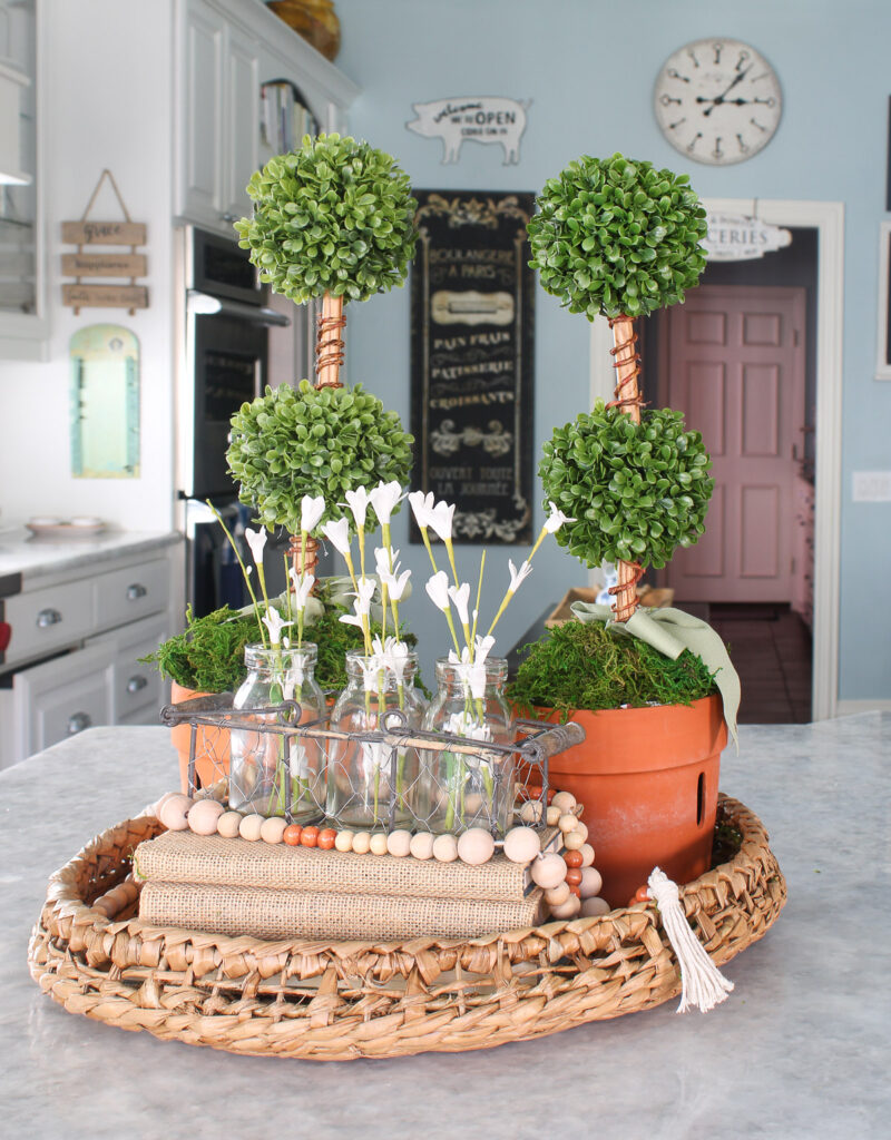 topiaries with burlap books and white flowers in a woven trap