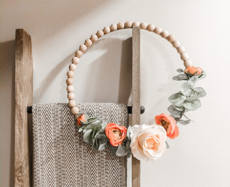 spring beaded wreath with flowers on a wood ladder