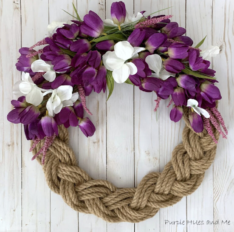 braided spring wreath with purple flowers on a wall