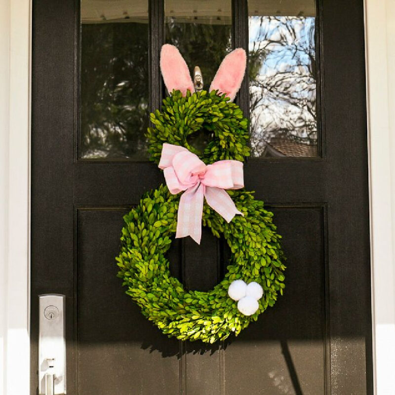 green bunny wreath with pink ears and pink bow on front door