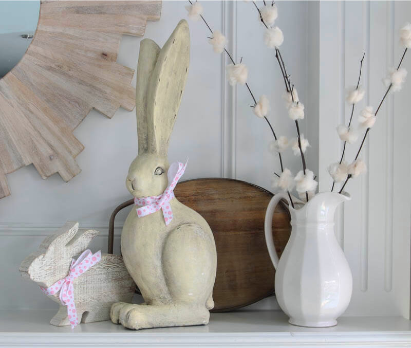 large white wood rabbie and small white bunny on mantel with white pitcher