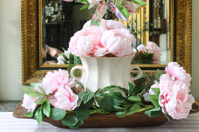 pink peonies in a white container on dough bowl with greenery