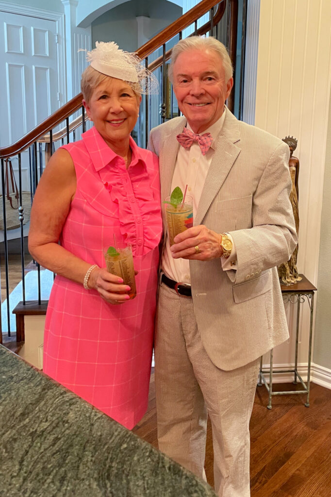 couple in pink dress and seersucker suite with mint juleps