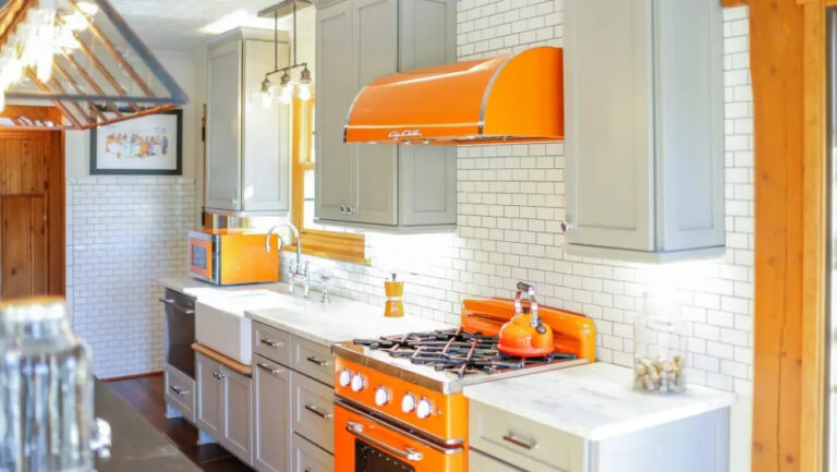colorful kitchen with orange stove and vent hood