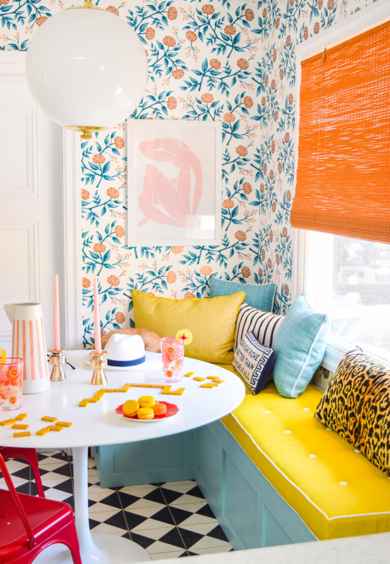 colorful kitchen with floral wallpaper, yellow bench, and orange window shade