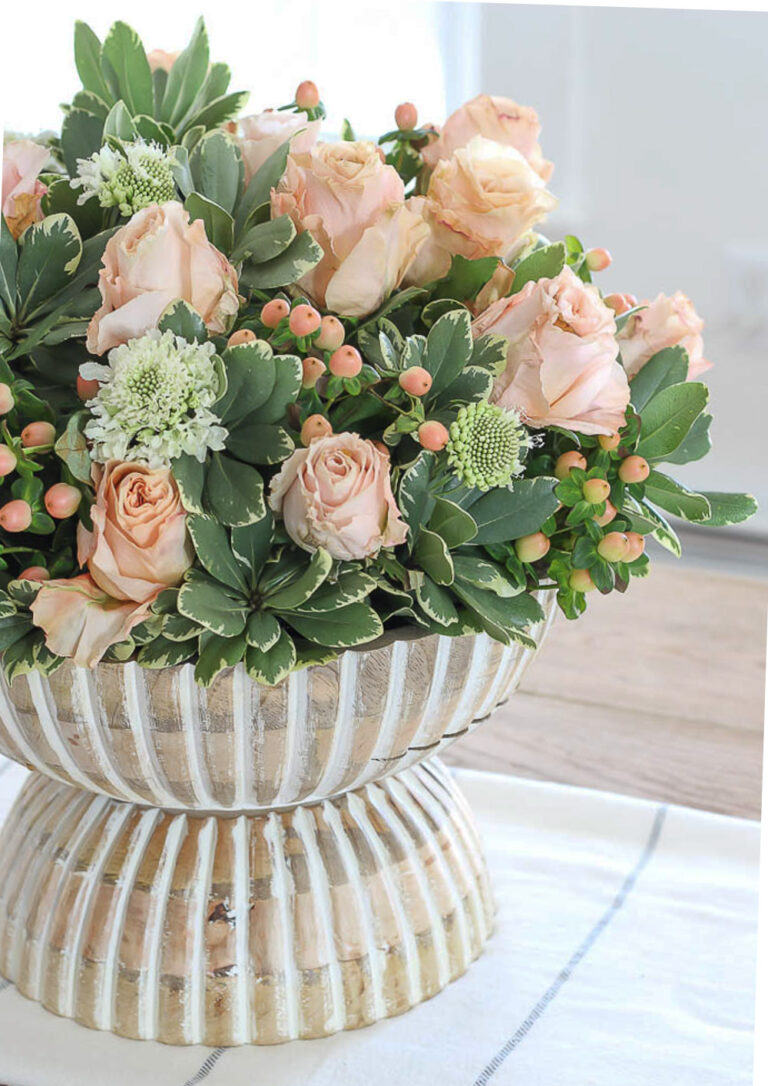 coral tulips with succulents in wood bowl pedestal.