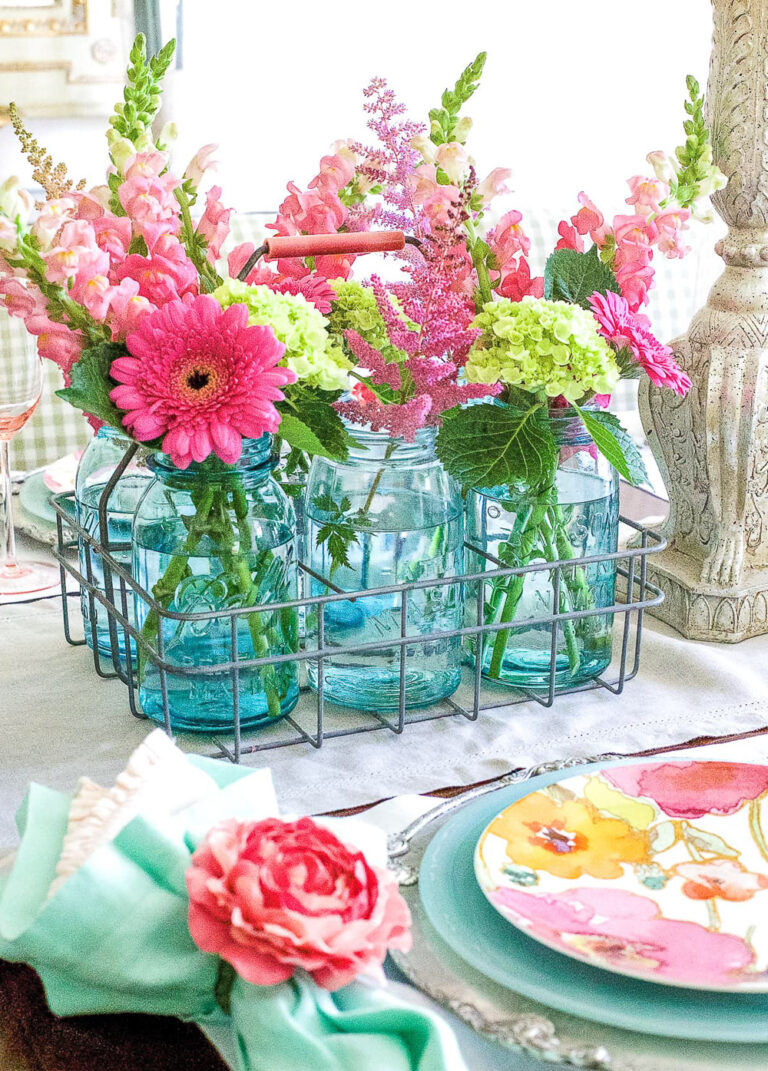 pink flowers in blue mason jars for spring centerpiece