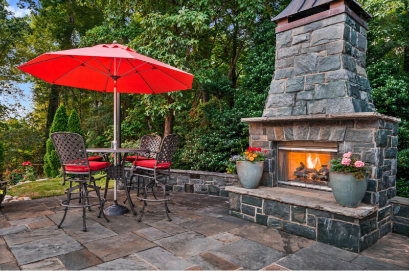 freestanding outdoor fireplace with red umbrella