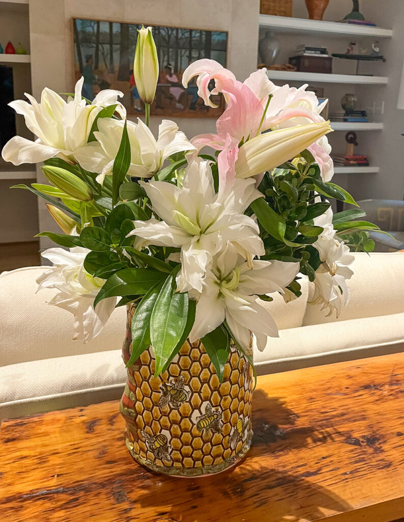 white lilies in metallic container on wood table