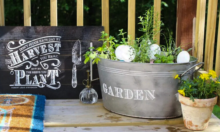 herb garden planted in a galvanized tub with "garden" written it.