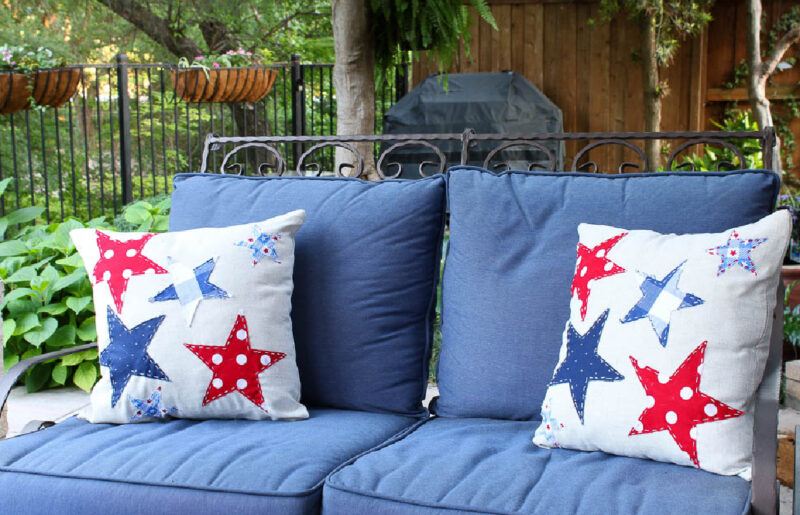 two patriotic pillows on blue loveseat