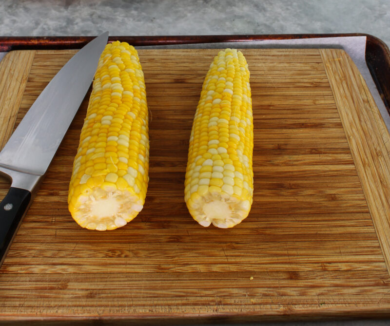 cooked corn on cutting board