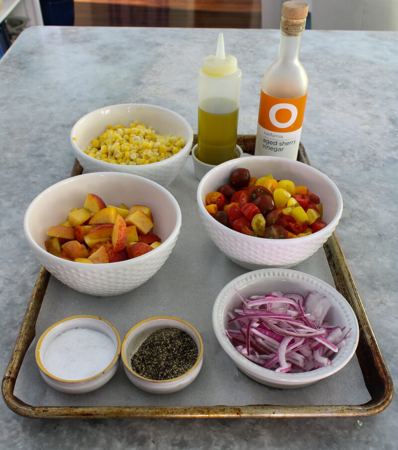 summer salad prepared ingredients in white bowls on tray