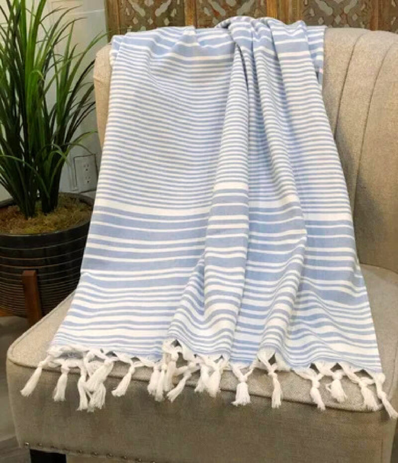 light blue and white stripe throw with fringe on a chair